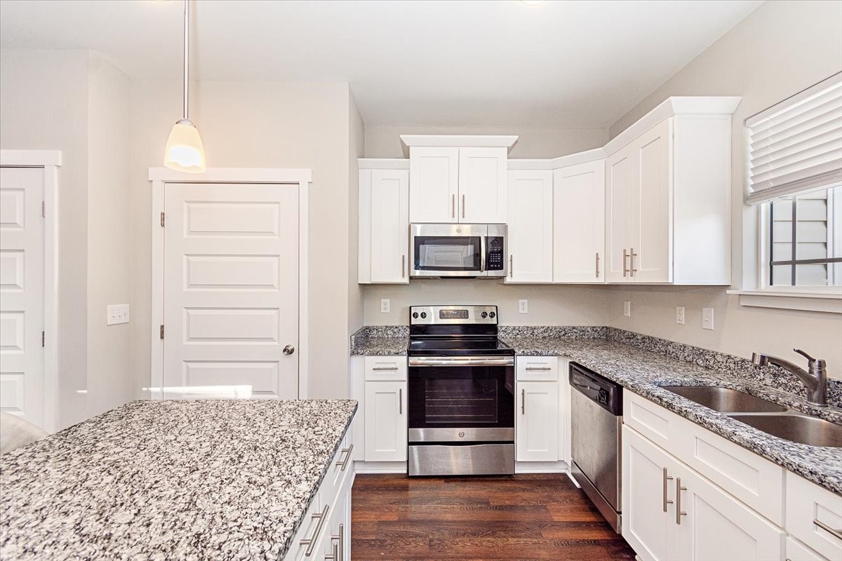 7000 Magnolia Crossings Spring Hill, TN 37174 - Photo 9 of 32 a kitchen with granite countertop white cabinets and stainless steel appliances