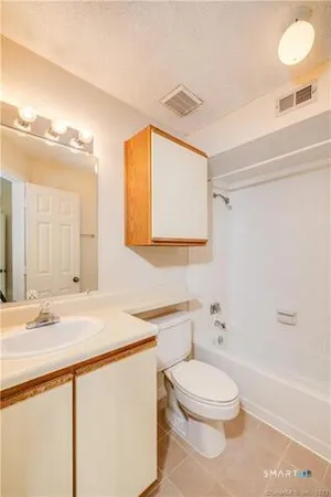 a bathroom with a granite countertop sink toilet a large mirror and shower
