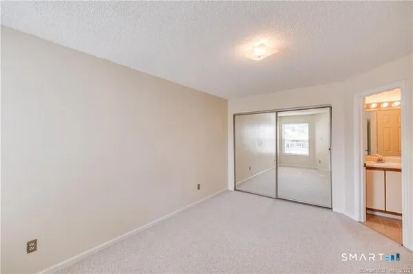 an empty room with closet and windows