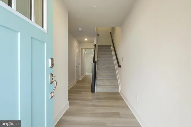 a view of a hallway with wooden floor and stairs