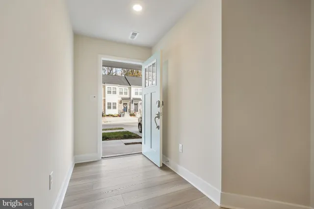 a view of a hallway with wooden floor and a window