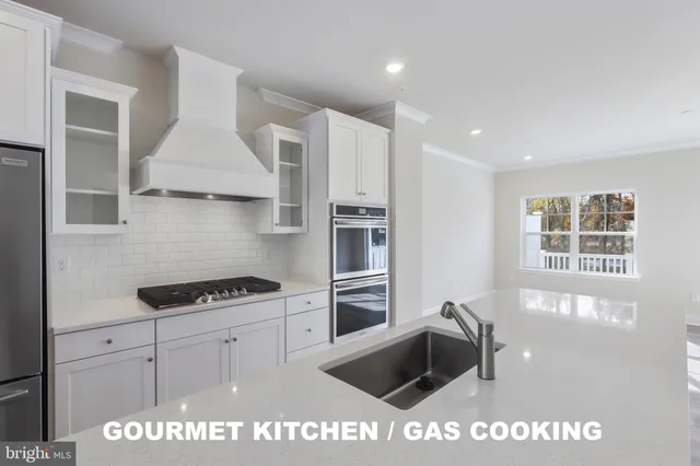 a kitchen with stainless steel appliances kitchen island granite countertop a stove and a sink