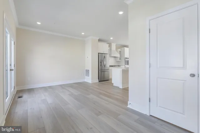 a view of a hallway with wooden floor and a window