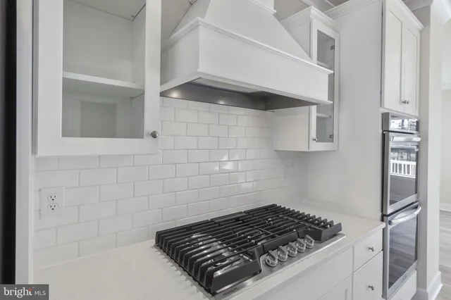 a kitchen with white cabinets and appliances