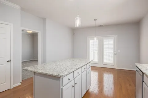 a view of kitchen and hall with wooden floor
