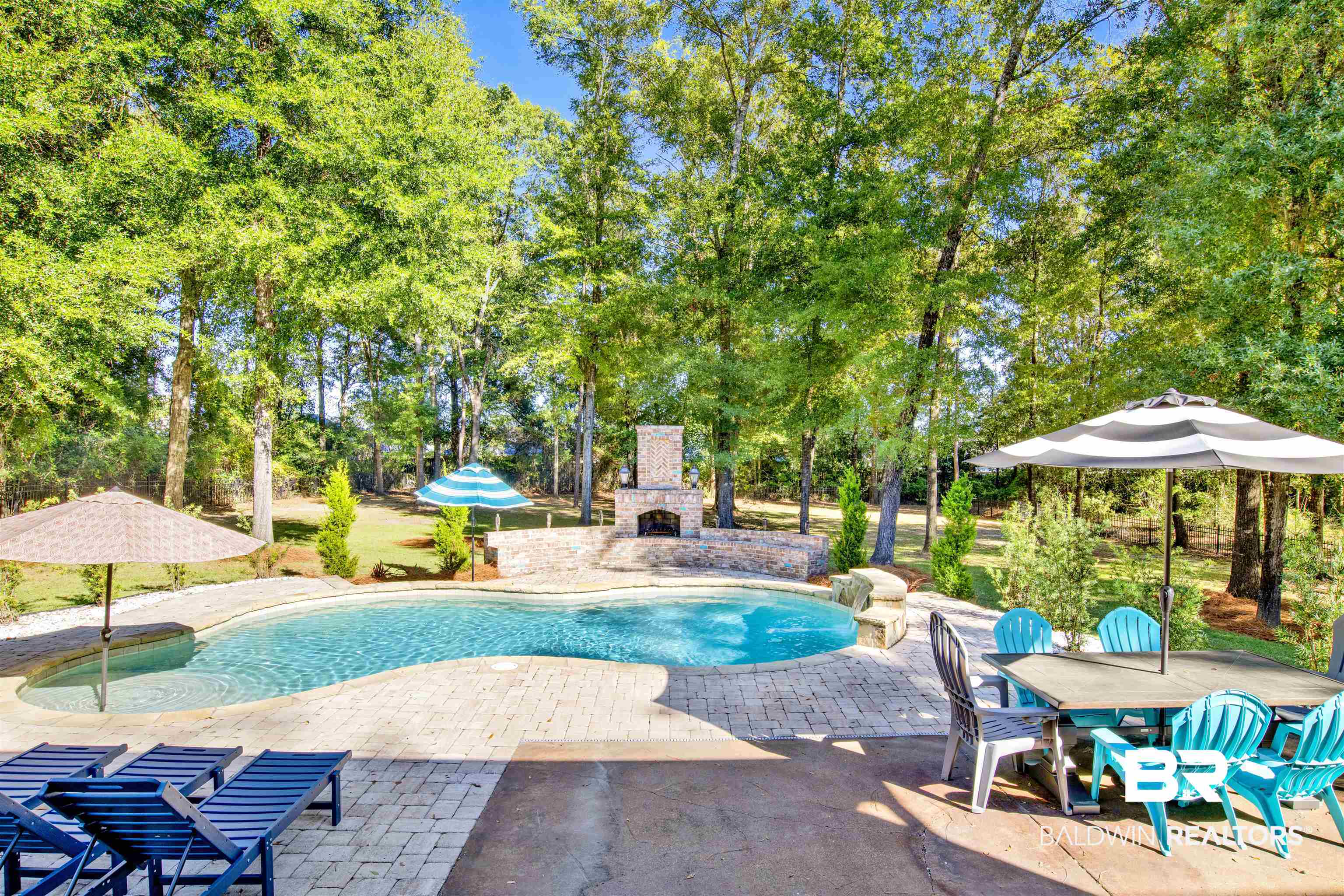 11116 Redfern Road Daphne, AL 36526 - Photo 16 of 46 Outdoor pool featuring a patio area, view of scattered trees, and an outdoor fireplace