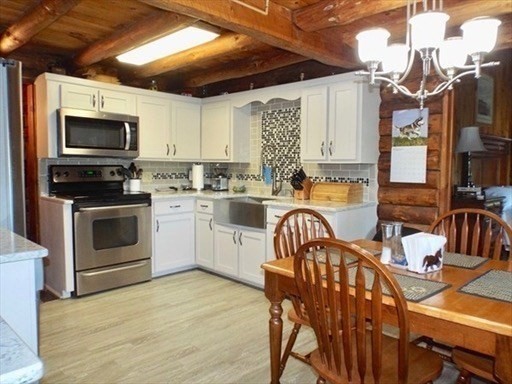 42 Shelburne Line Road Colrain, MA 01340 - Photo 3 of 41 a kitchen with stainless steel appliances a stove a sink dishwasher a dining table and chairs with wooden floor
