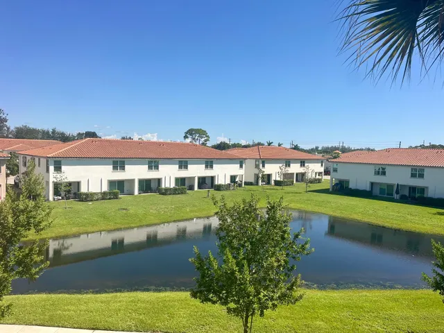 a view of a big house with a big yard and potted plants