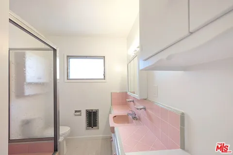 a bathroom with a glass shower door and a sink