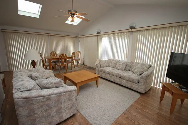 a living room with furniture a ceiling fan and a window
