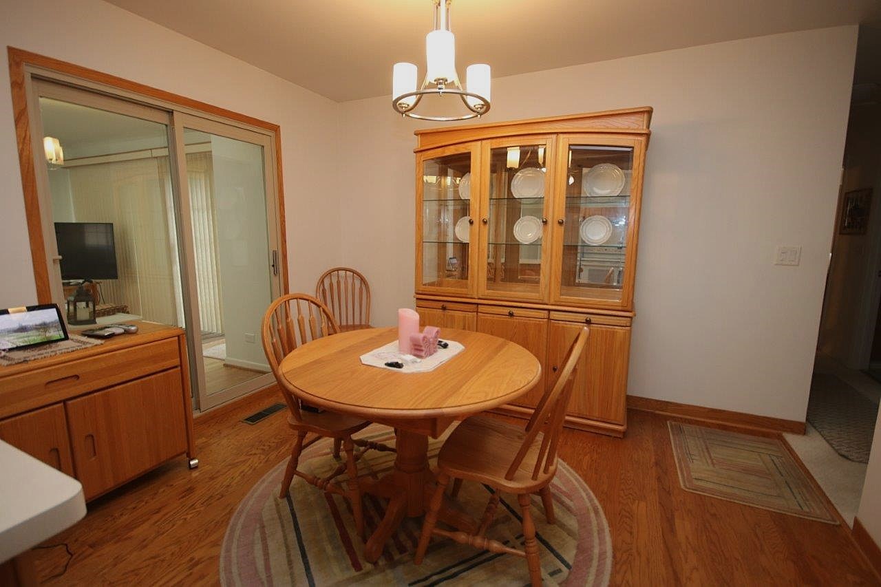 209 Gladys Avenue Fox River Grove, IL 60021 - Photo 8 of 23 a dining room with furniture a chandelier and wooden floor