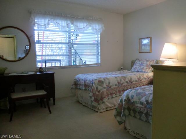 4372 27th Court Southwest, Unit 210 Naples, FL 34116 - Photo 17 of 19 a bedroom with a bed chair and a large window