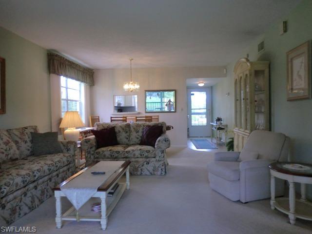 4372 27th Court Southwest, Unit 210 Naples, FL 34116 - Photo 3 of 19 a living room with furniture and a large window