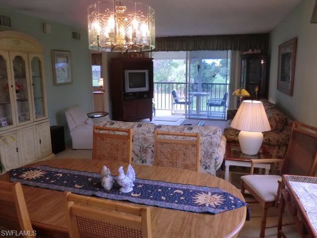 4372 27th Court Southwest, Unit 210 Naples, FL 34116 - Photo 7 of 19 a living room with furniture chandelier and a fireplace