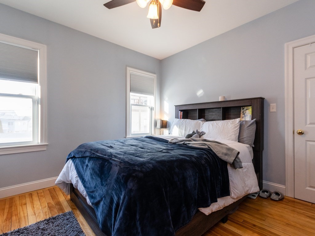 31-33 College Hill Road Somerville, MA 02144 - Photo 25 of 38 a bed sitting in a bedroom next to a window and a chandelier