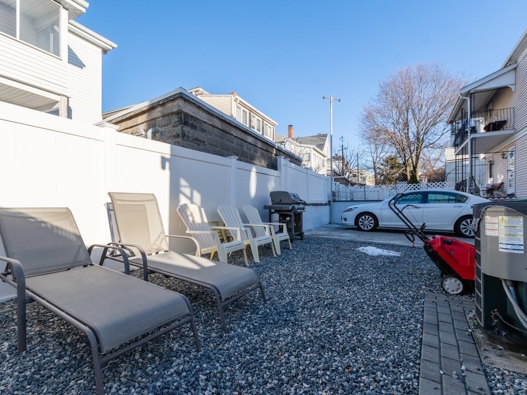 31-33 College Hill Road Somerville, MA 02144 - Photo 33 of 38 a view of a patio with table and chairs with wooden floor and barbeque grill