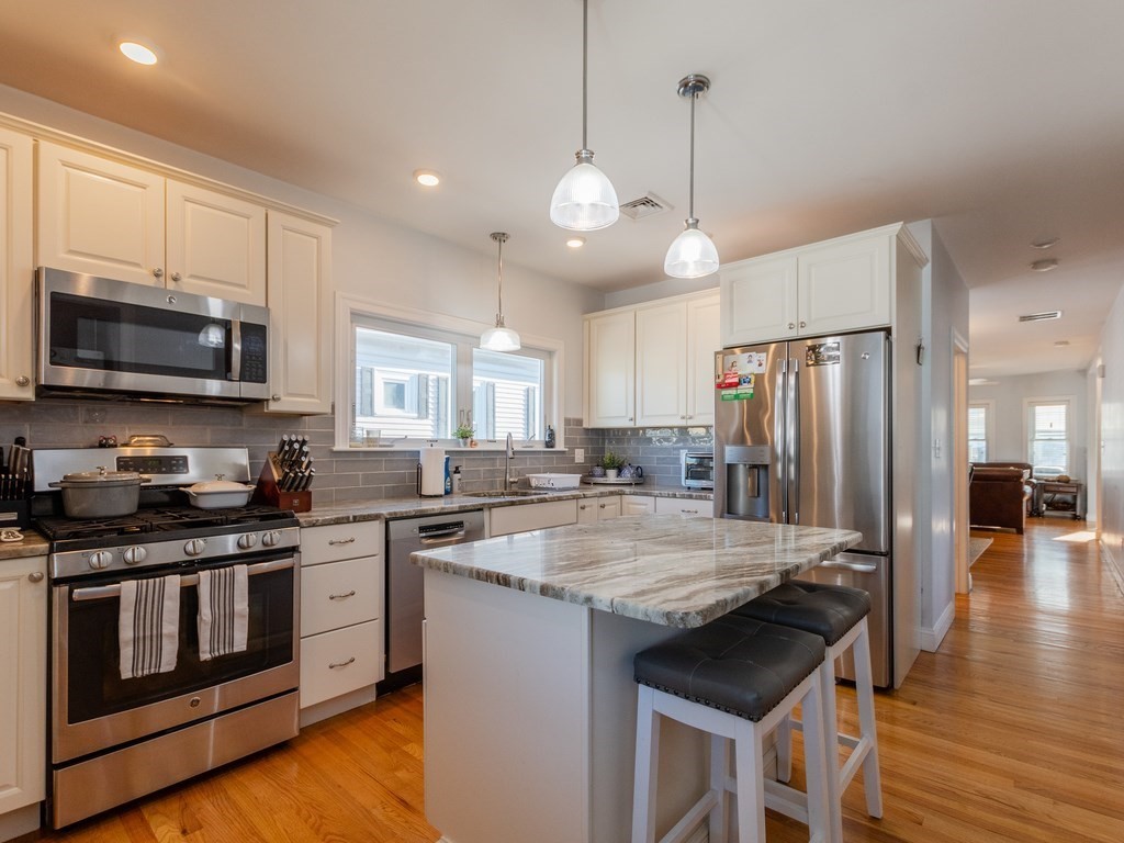 31-33 College Hill Road Somerville, MA 02144 - Photo 8 of 38 a kitchen with stainless steel appliances granite countertop a stove a sink and a refrigerator