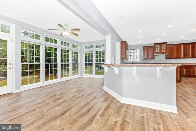 a kitchen with stainless steel appliances granite countertop a stove a sink dishwasher and a refrigerator with wooden floor