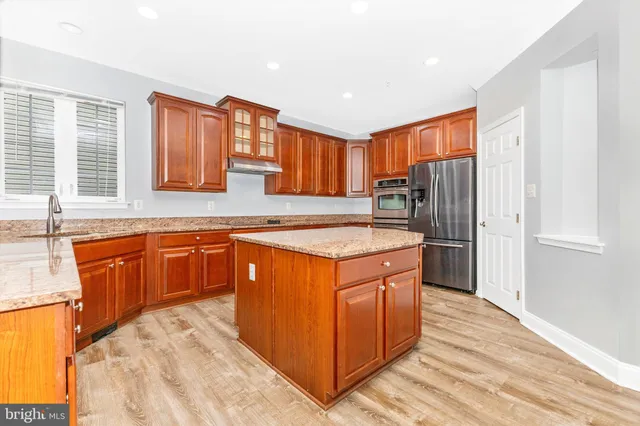a view of an empty room with a large window and wooden floor