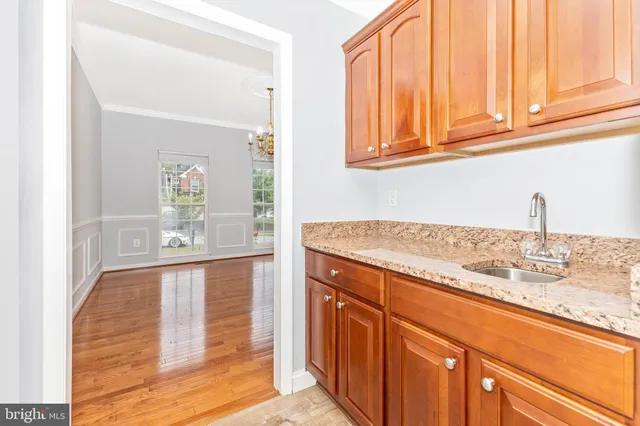 a view of staircase with lots of frames on wall and wooden floor