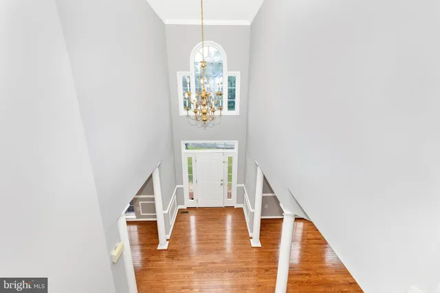a view of empty room with wooden floor and ceiling fan