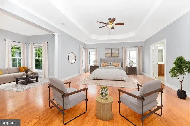 a view of a hallway with wooden floor and a living room