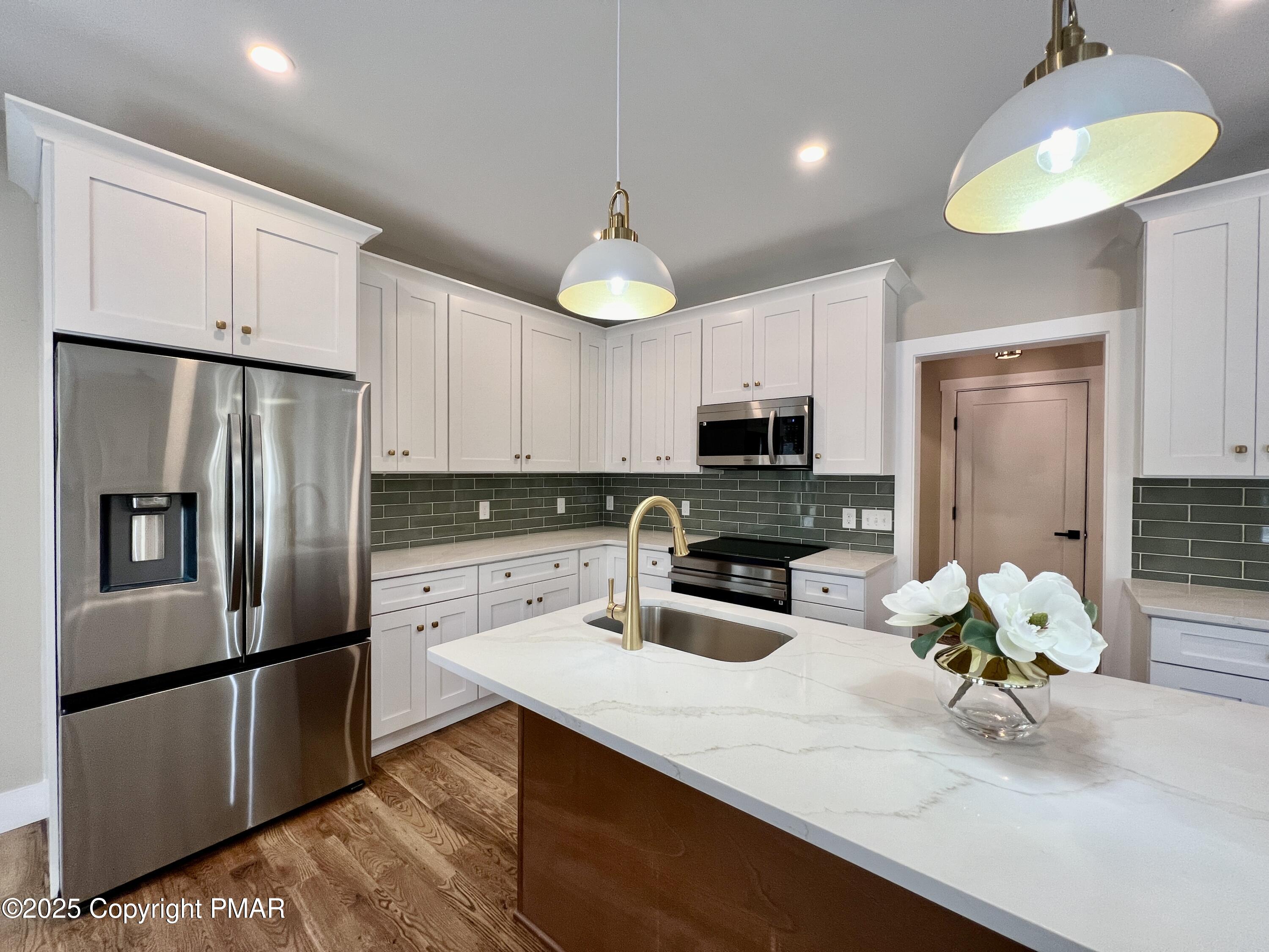 253 Hawthorn Lane Kunkletown, PA 18058 - Photo 11 of 39 a kitchen with stainless steel appliances a refrigerator a sink a stove white cabinets and wooden floor