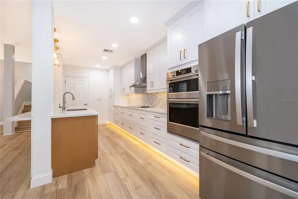 a kitchen with stainless steel appliances a refrigerator sink and microwave