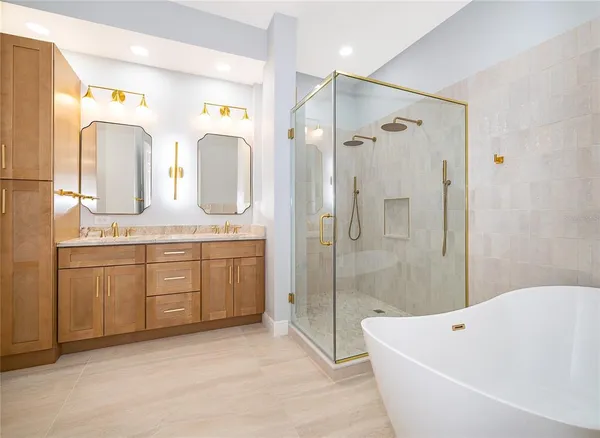 a spacious bathroom with a granite countertop tub sink a mirror a shower and vanity