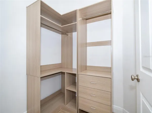 a view of walk in closet with empty racks