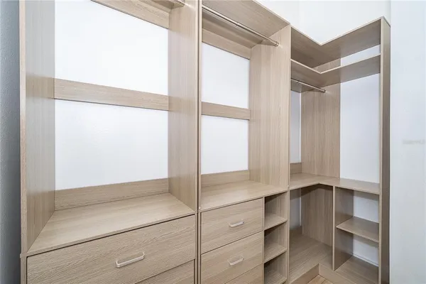 a view of walk in closet with empty racks