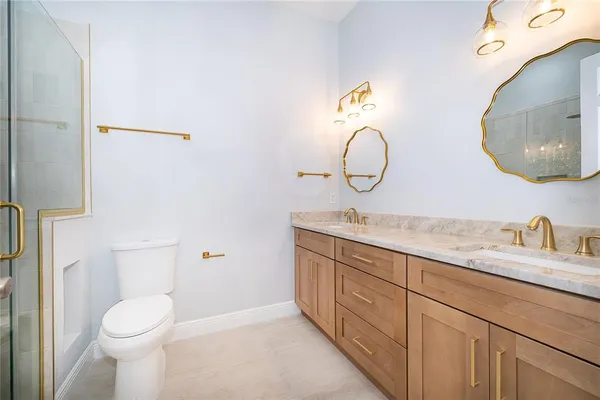 a bathroom with a granite countertop sink mirror and toilet