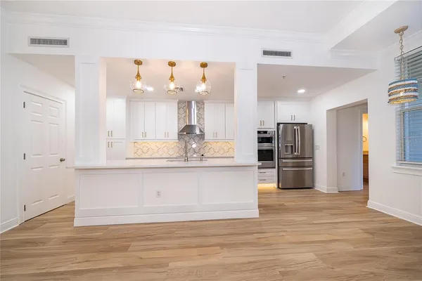 a large kitchen with granite countertop a large counter top stainless steel appliances and cabinets