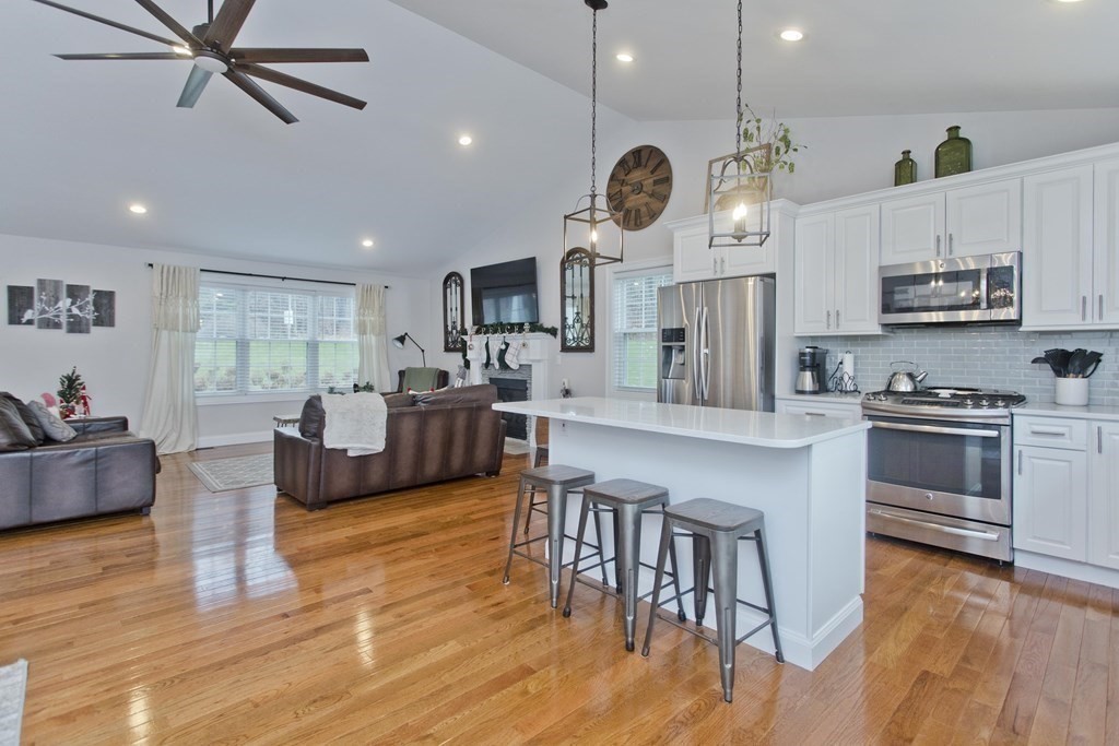 19 Valley Road Southampton, MA 01073 - Photo 12 of 32 a large kitchen with stainless steel appliances granite countertop a stove a oven a dining table and chairs with wooden floor