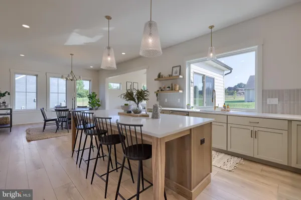a kitchen with stainless steel appliances granite countertop wooden floor dining table and chairs
