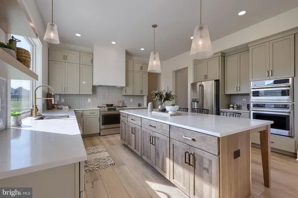 a kitchen with kitchen island granite countertop a sink a counter top space stainless steel appliances and cabinets