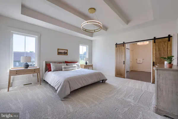 a spacious bedroom with a bed and a chandelier