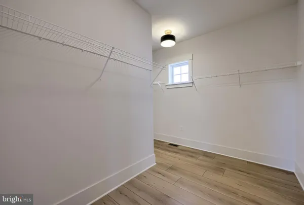 a view of a room with wooden floor and white walls