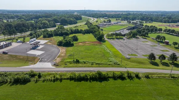 an aerial view of a residential houses with outdoor space and lake view