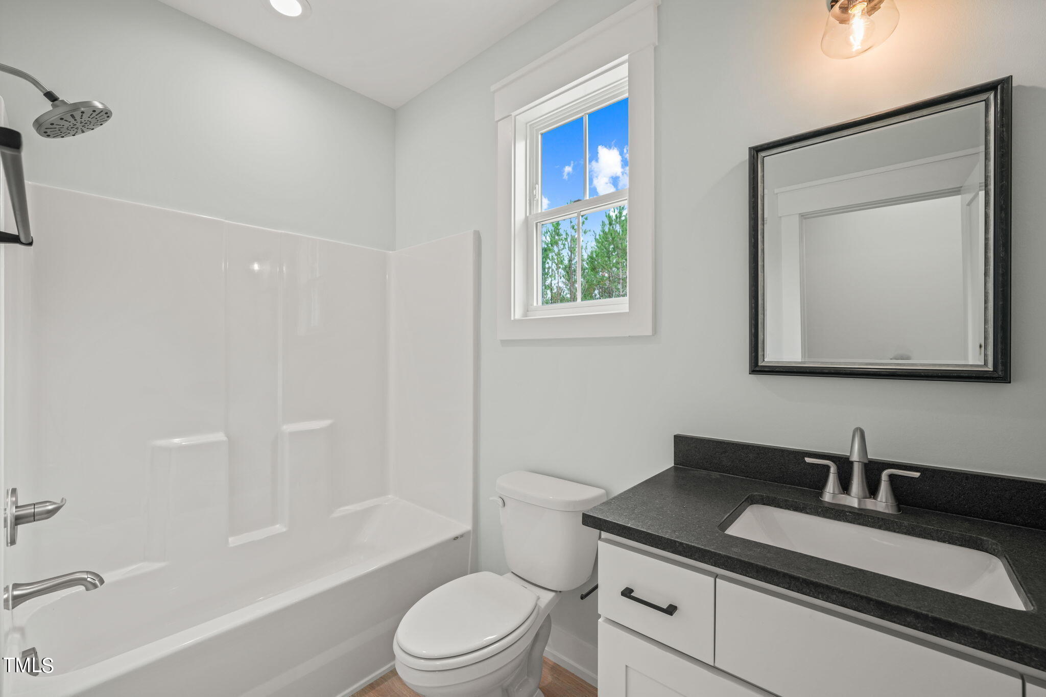 210 Pilot Ridge Road Zebulon, NC 27597 - Photo 34 of 46 a bathroom with a granite countertop sink toilet a mirror and shower