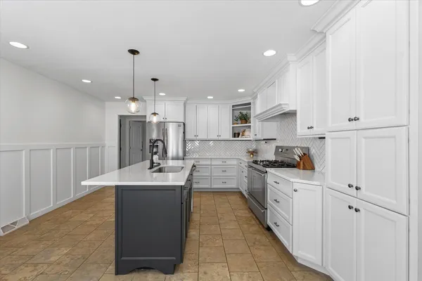 a kitchen with stainless steel appliances kitchen island granite countertop a sink and cabinets