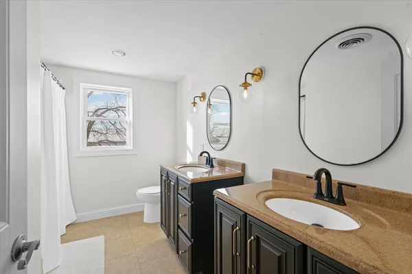 a bathroom with 2 sink and a mirror