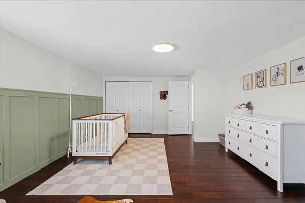 a view of an empty room with closet and wooden floor