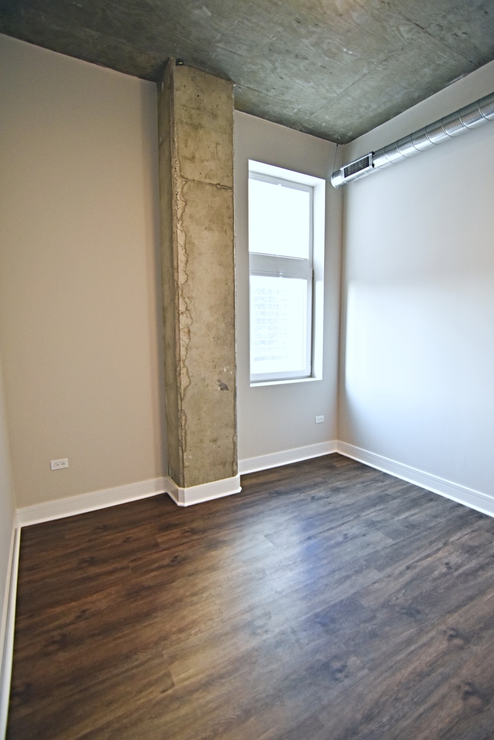 Undisclosed Address Chicago, IL 60613 - Photo 8 of 11 an empty room with wooden floor and windows