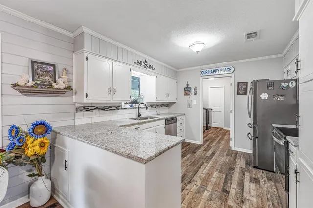 a kitchen with stainless steel appliances granite countertop a sink refrigerator and microwave