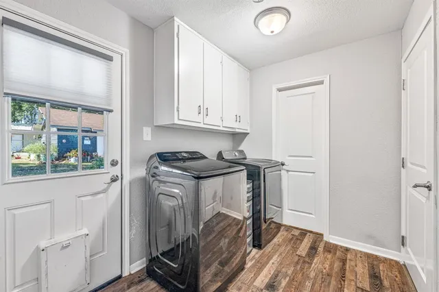 a view of a kitchen with fridge and wooden floor