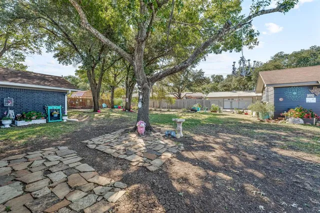 a view of a house with backyard and a tree