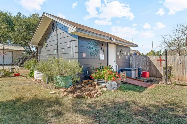 a view of a house with a yard and potted plants