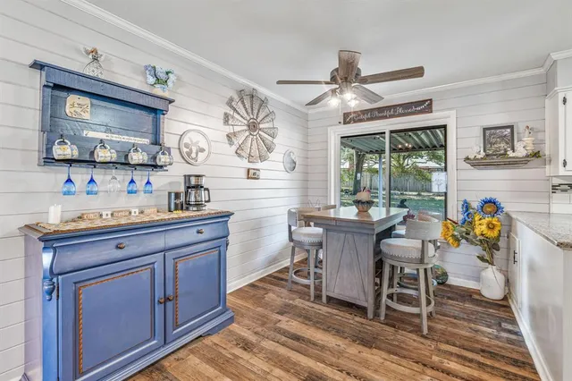 a dining hall with stainless steel appliances granite countertop a stove a sink dishwasher and a dining table with wooden floor