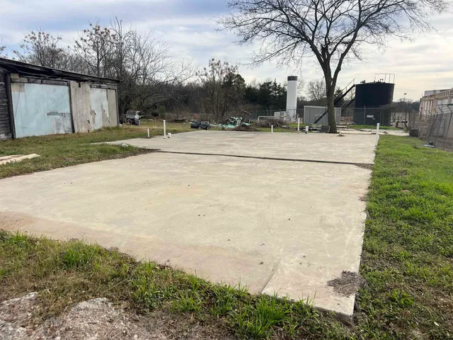 a view of a white house with a yard and large tree